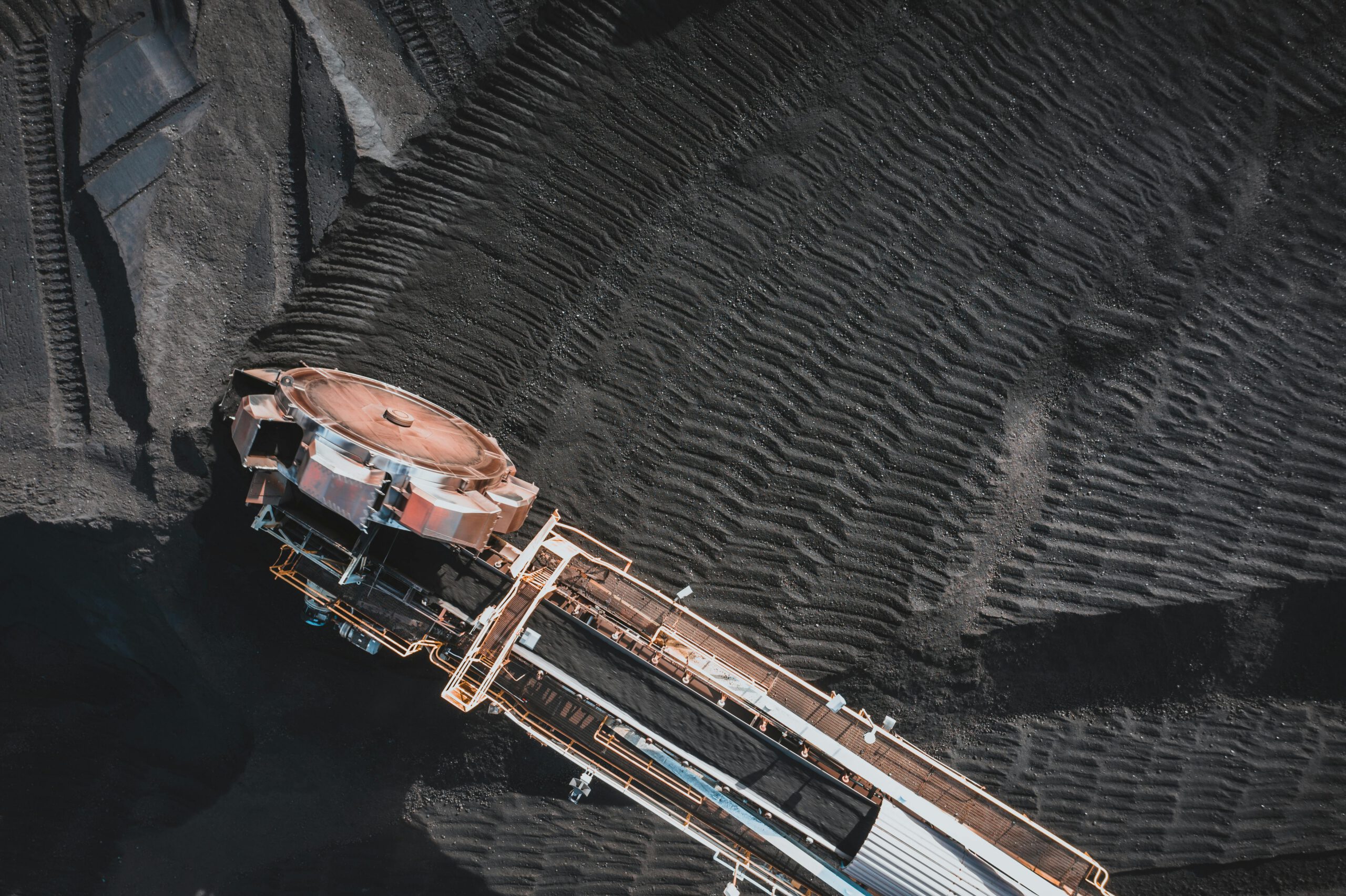 Aerial view of an industrial conveyor system at a coal mining site, showcasing engineering and machinery.