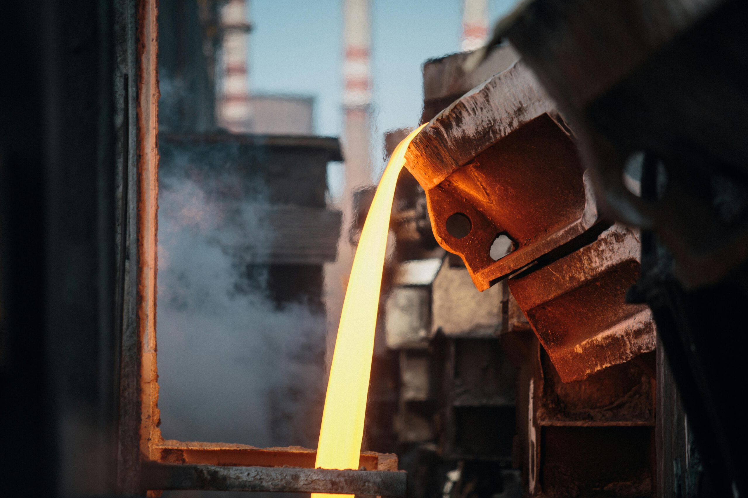 Close-up of molten metal pouring in a foundry, showcasing industrial processes.